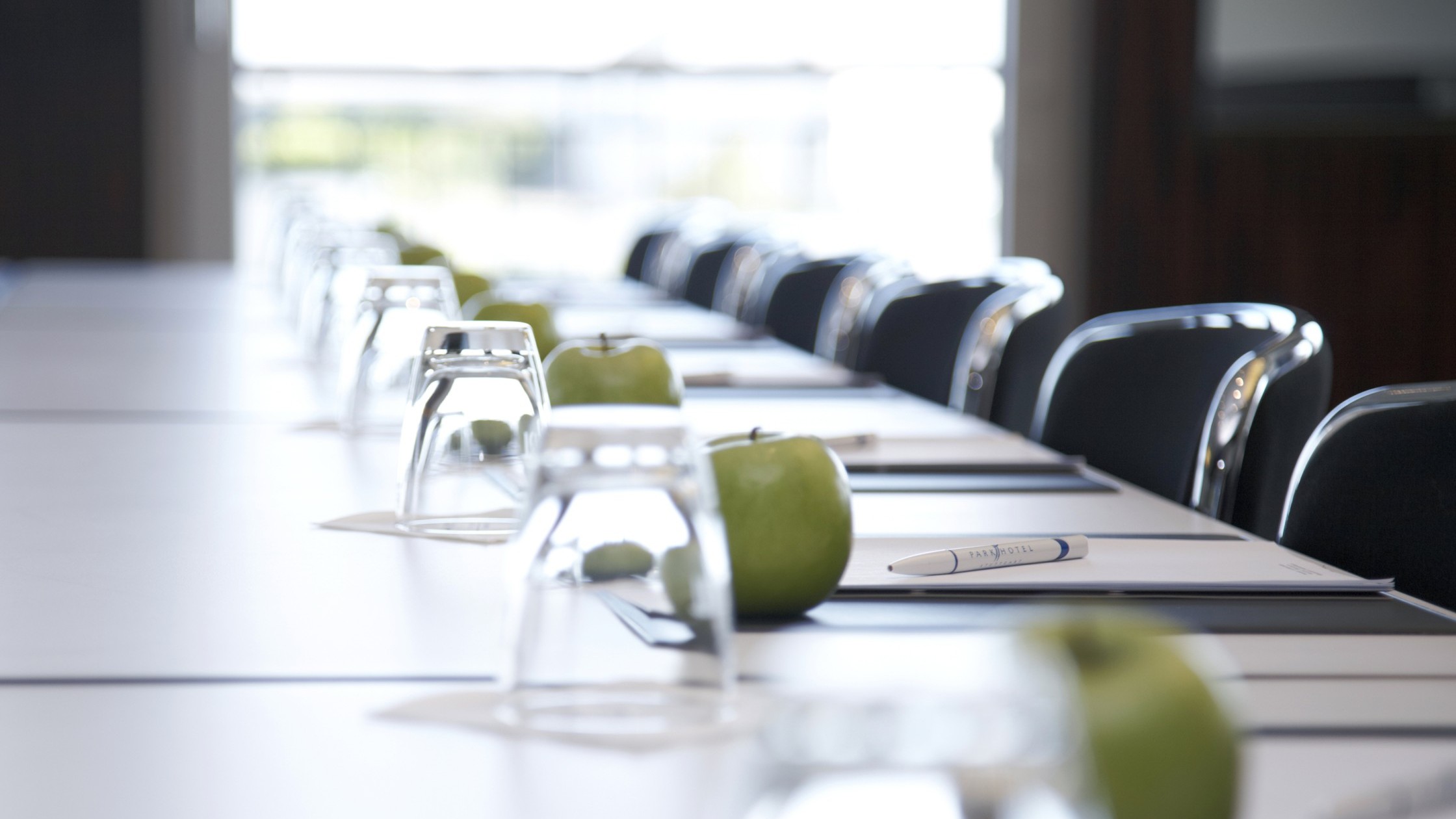Tagungstische mit Glas und Apfel